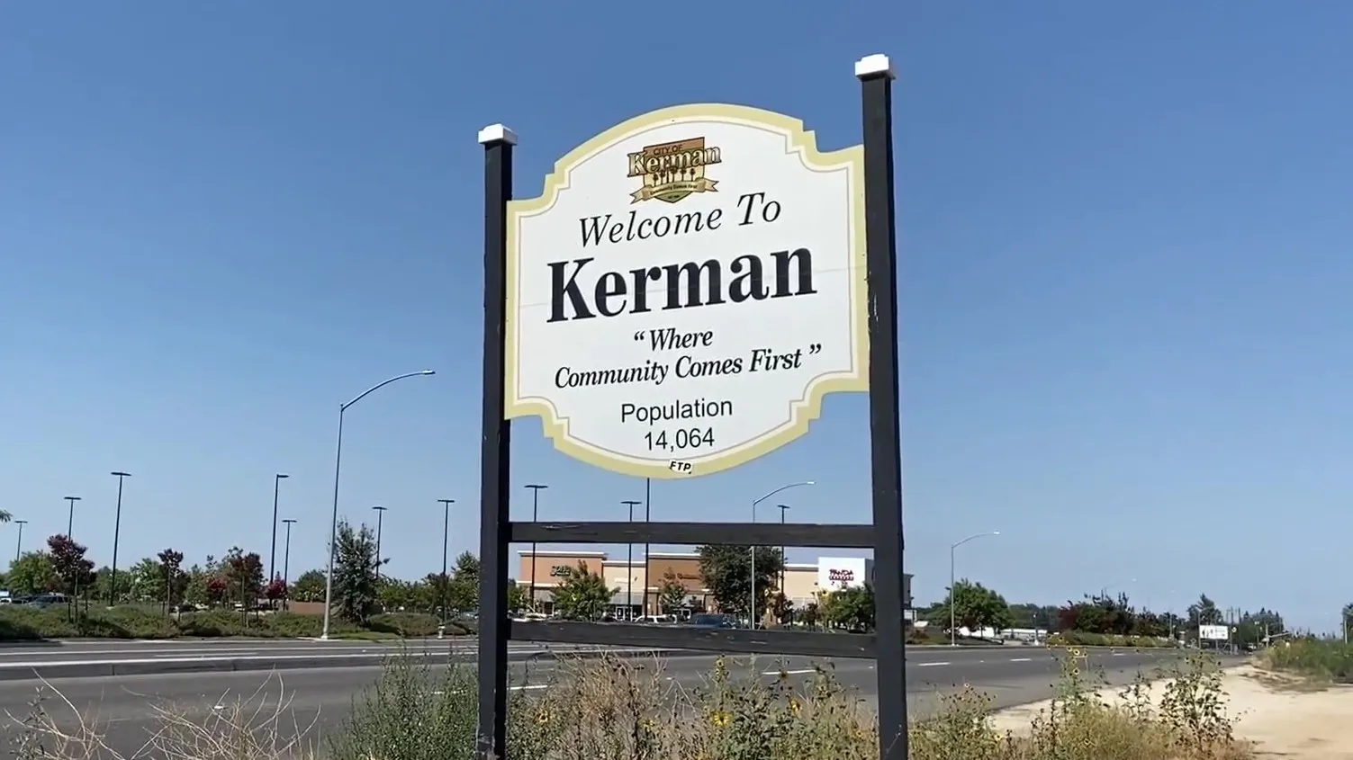 Entrance sign to Kerman California surrounded by palm trees